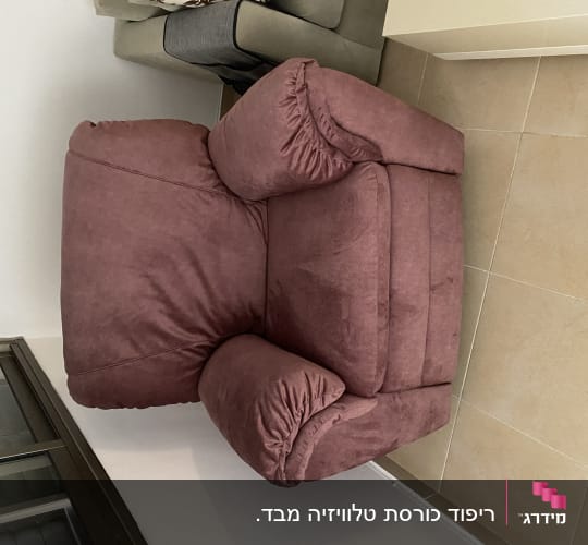 כורסה מרופדת בצבע ורוד כהה עם כריות צד